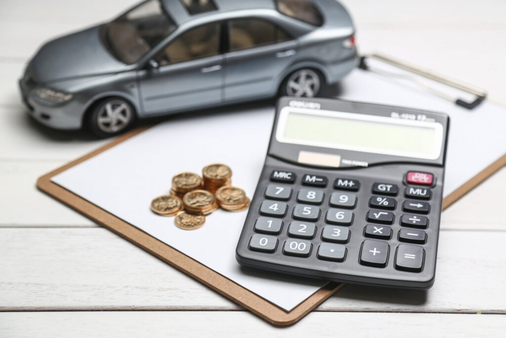 A car model, coins, and a calculator representing the idea of budgeting or planning for car financing.