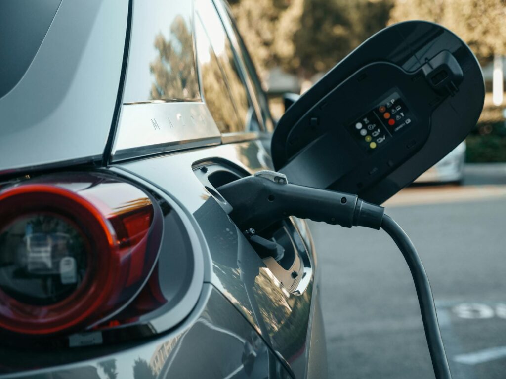 A EV car charging at a outdoor car park. 