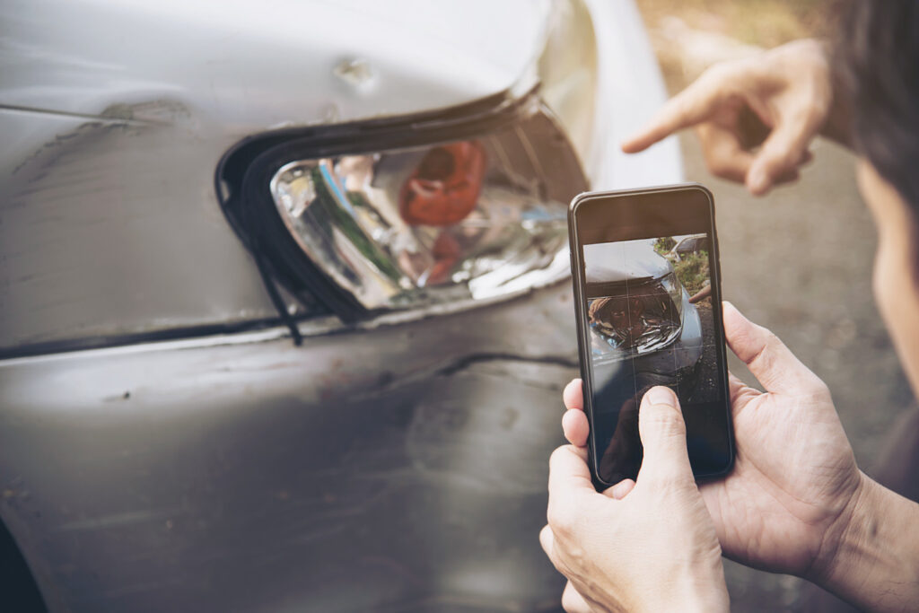 A car driver taking photos after a car accident. 