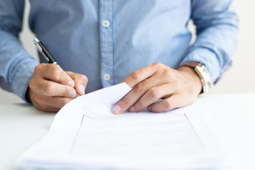 A man is signing a document.