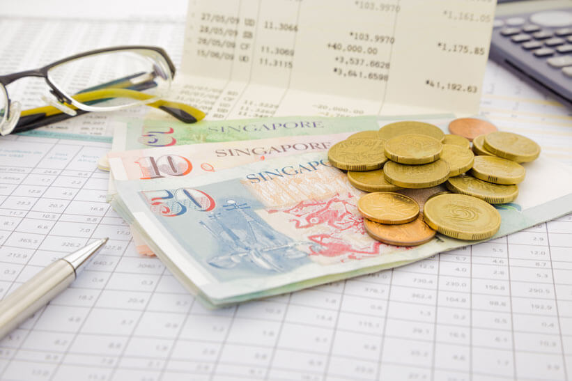 singapore bank notes and coins on account book