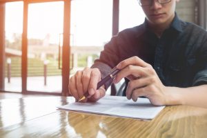 All you need to know about early settlement for car loans in Singapore Man signing document